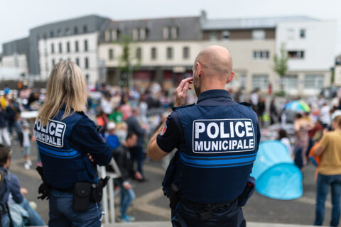 un policier et une policière de dos au milieu de la foule