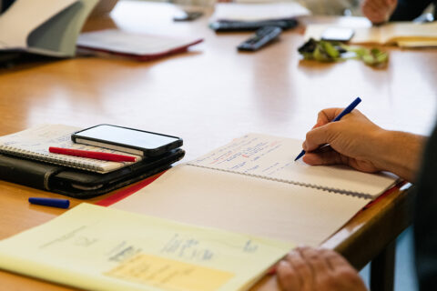 main prenant des notes sur un cahier