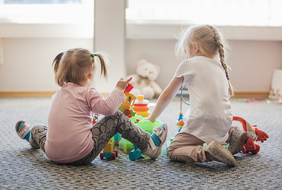 deux-petites-filles-assises-sur-le-sol-jouant.jpg