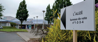 Panneau blanc d'une salle de spectacle indiquant l'emplacement d'un bureau de vote.