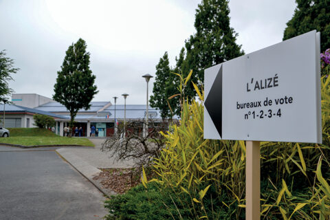 Panneau blanc d'une salle de spectacle indiquant l'emplacement d'un bureau de vote.