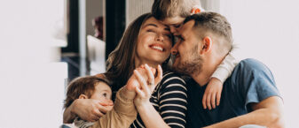 Famille composée de 2 parents et de 2 jeunes enfants qui s'amusent ensemble