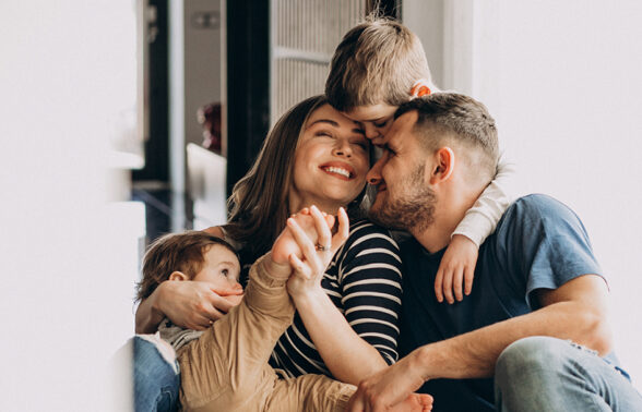 Famille composée de 2 parents et de 2 jeunes enfants qui s'amusent ensemble
