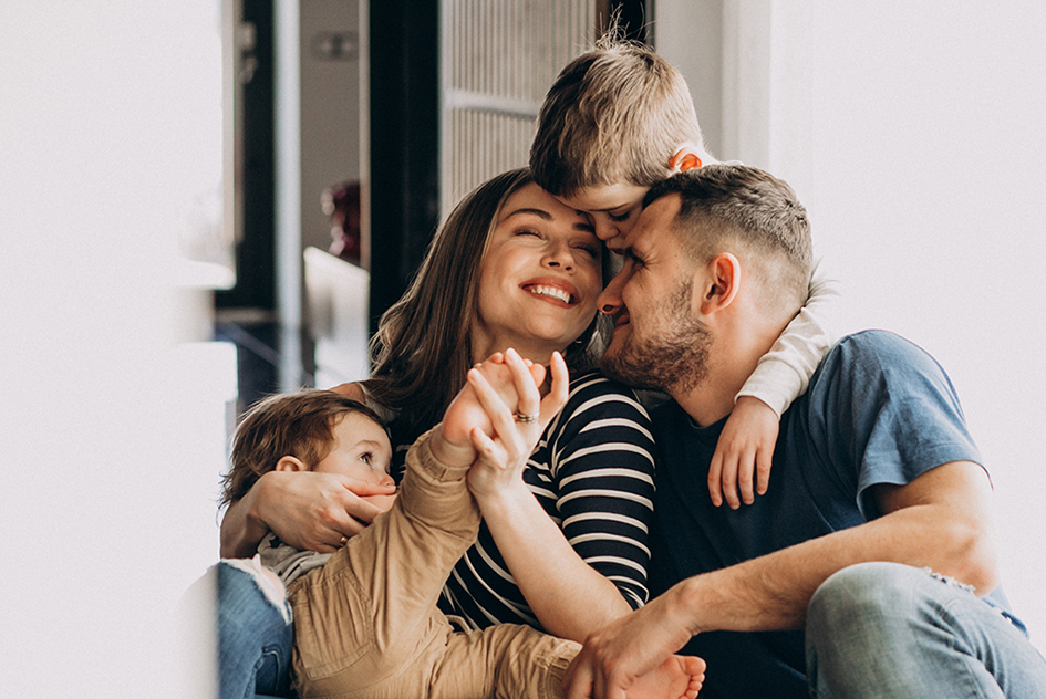 Famille composée de 2 parents et de 2 jeunes enfants qui s'amusent ensemble