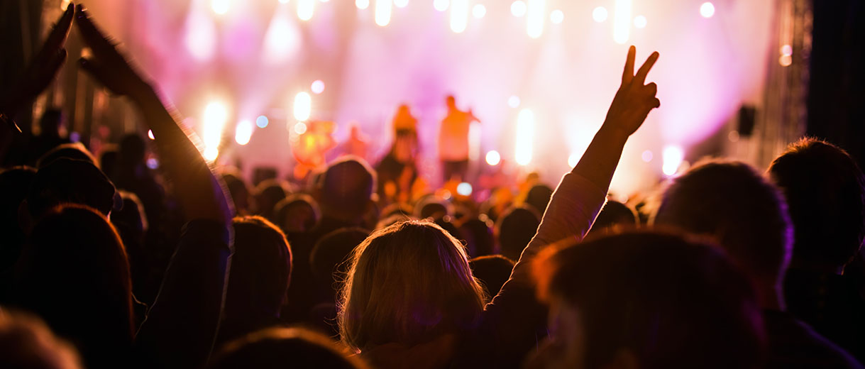 Public à un concert dans une salle plongée dans l'obscurité
