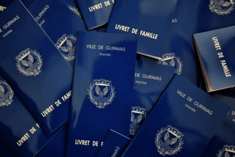 plusieurs livrets de famille étalés sur une table. couverture bleue et mention de la ville de guipavas sur la couverture