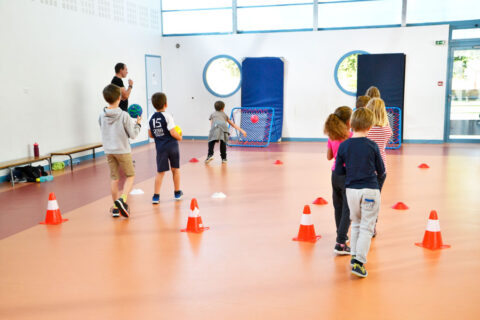 jeunes enfants qui jouent au handball dans une salle de sport