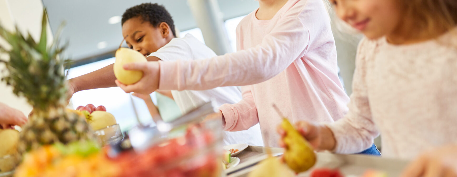 enfants servant des fruits au self
