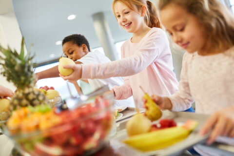 enfants servant des fruits au self
