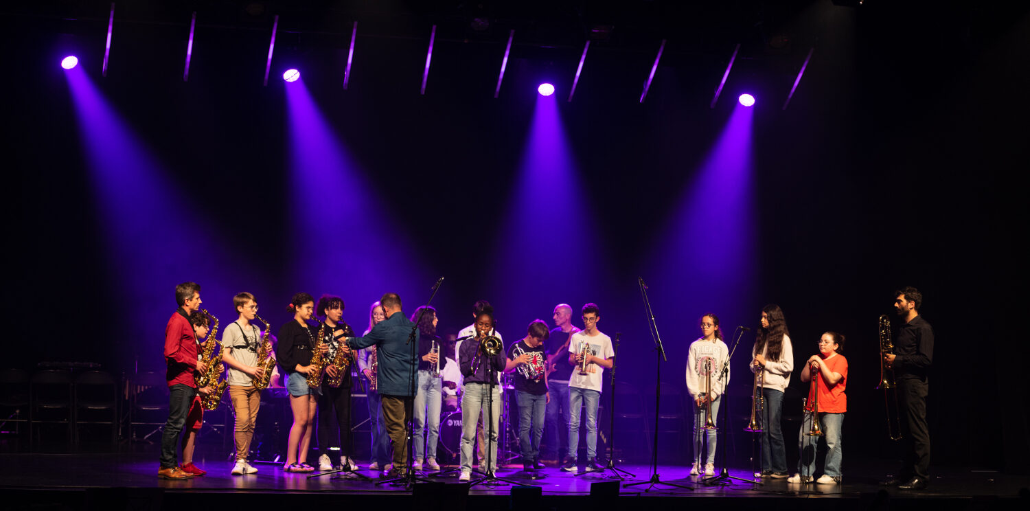 Salle de spectacle plongée dans l'obscurité et éclairée de spots violets