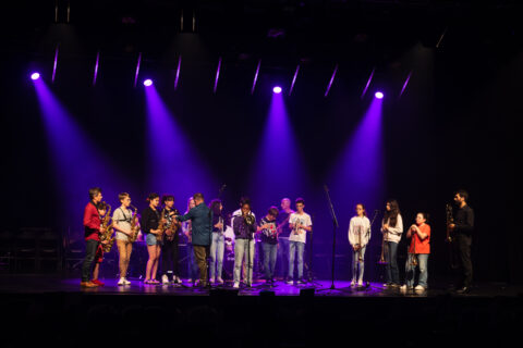 Salle de spectacle plongée dans l'obscurité et éclairée de spots violets
