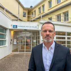 Portrait d'un homme brun, barbe courte grisonnante, devant la clinique Penn ar Dalar de Guipavas, dédiée à la santé mentale.