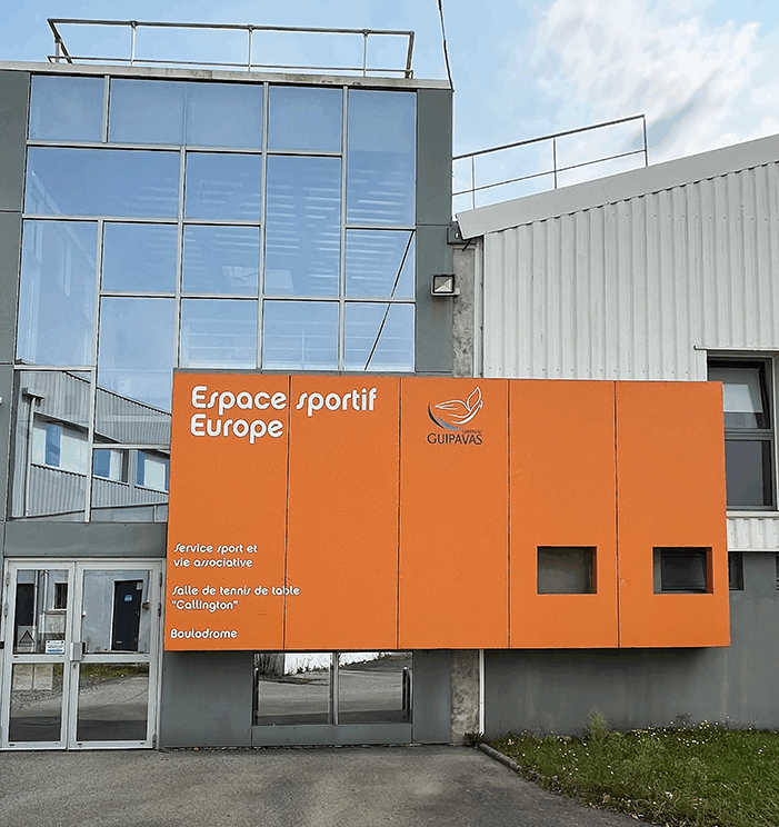 Bâtiment à la façade orangée sur lequel est inscrit "Espace sportif Europe".