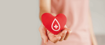 Une femme qui tend le bras. Un zoom est fait sur sa main, sur laquelle repose un coeur rouge. Sur ce coeur, la représentation d'une goutte de sang.