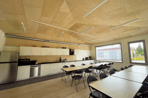 Pièce de la salle de spectacles l'aAlizé à Guiupavas. La salle a été renovée. La salle a une ambiance feutrée grâce à des couleurs chaudes (beige au mur et parquet bois au sol). De grandes baies vitrées apportent de la lumière à la pièce. Il s'agit d'une salle qui servira à l'accueil des artistes.