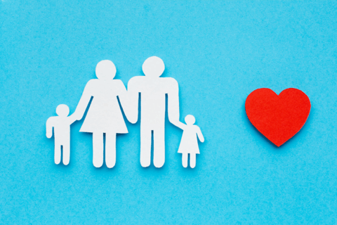 aplat de couleur bleue sur lequel se trouvent 4 figurines en papier blanc (on devine qu'il s'agit de parents et de 2 enfants). Sur le côté droit du visuel, un gros coeur rouge.