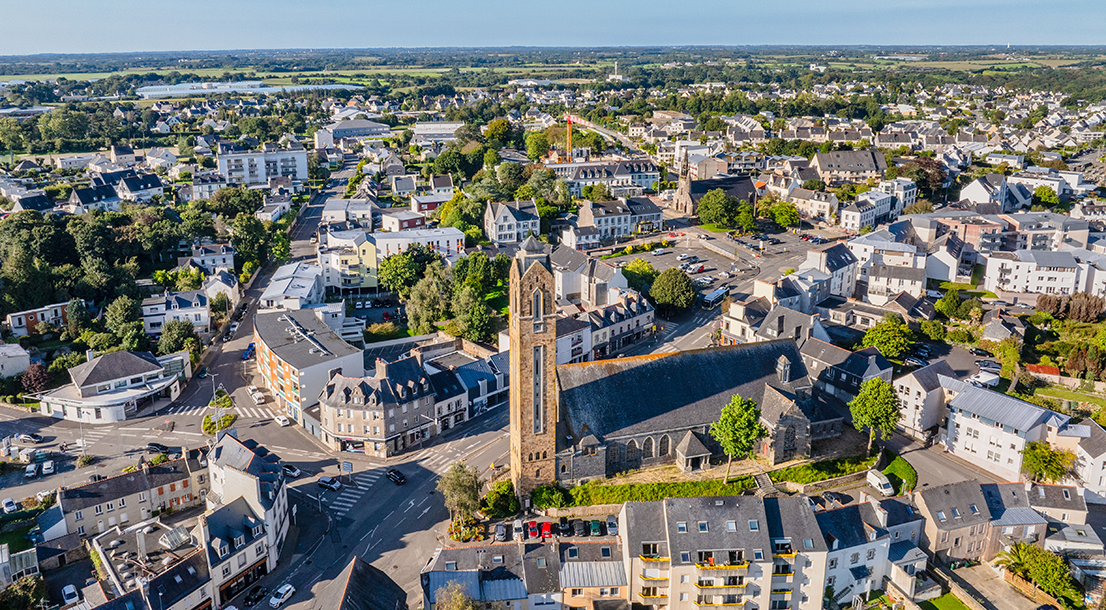 Vue aérienne de la ville de guipavas sous un grand ciel bleu. Au centre : l'église.