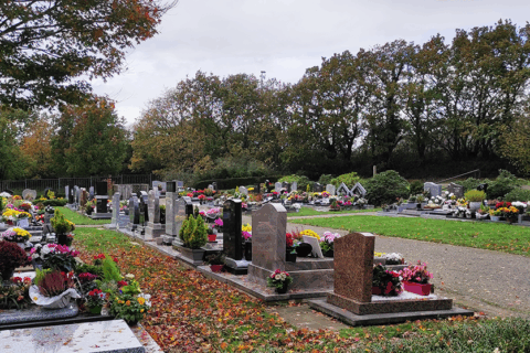 Tombes fleuries au sein d'un cimetière (celui de Lavallot, à Guipavas). Il fait gris. Des arbres bordent le cimetière.
