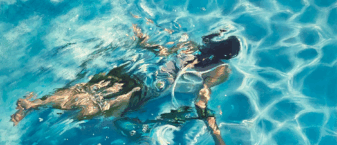 femme qui nage sous l'eau dans une piscine.