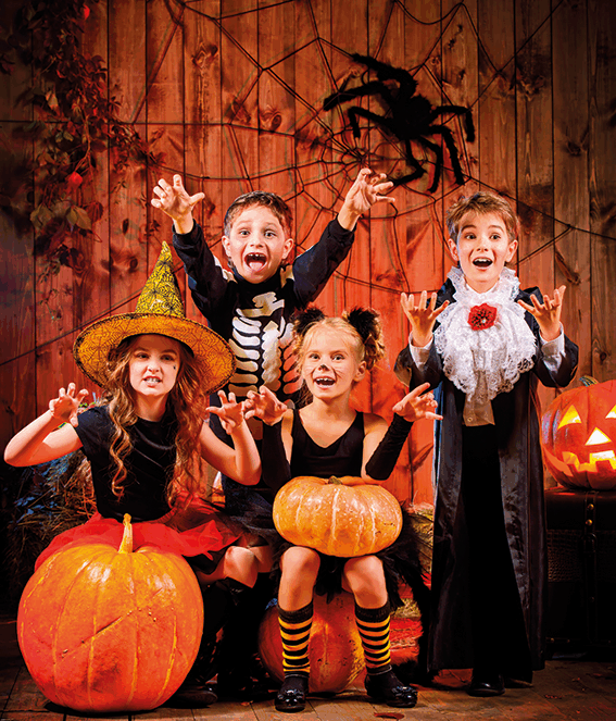 enfants joyeux. ambiance orangée rappelant halloween. les enfants sont tous déguisés en personnages d'Halloween