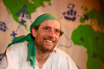 photo portrait d'un homme souriant habillé en pirate devant une carte aux trésors - Agrandir l'image, fenêtre modale