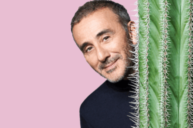 Elie Semoun, humoriste. Homme brun qui se cache derrière un cactus