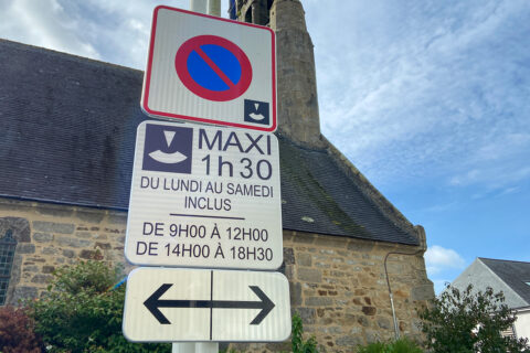 panneau de signalisation expliquant que le stationnement en zone bleue est limité à 1h30 maxi, du lundi au samedi inclus, de 9h à 12h et de 14h à 18h30. Le panneau est positionné à proximité de la chapelle Notre-Dame du Reun au centre-ville