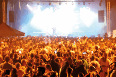 scène de concert en extérieur. Au fond, la scène. Nombreux spectateurs. Scène prise pendant la nuit. Ceci pour illustrer la fête de l'été qui se tient chaque année à guipavas.