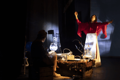 scène de danse, ambiance très sombre. Une femme au centre de l'image lève les bras au ciel. - Agrandir l'image, fenêtre modale