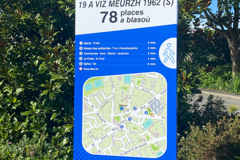 Nouveau panneau signalétique indiquant l'emplacement d'un parking dans la ville de Guipavas. En l'occurrence il s'agit du parking de la place du 19 mars 1962. Le panneau est sur fond bleu foncé. Il indique également le temps qu'il faut pour rejoindre certains centres d'intérêt de la ville.