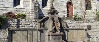 le monument aux mort de Guipavas en pierre, surmonté d'un crucifix. Il comporte oiutre les noms gravés des vicitimes, 2 statues d'une femme et de son fils.