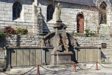 le monument aux mort de Guipavas en pierre, surmonté d'un crucifix. Il comporte oiutre les noms gravés des vicitimes, 2 statues d'une femme et de son fils.