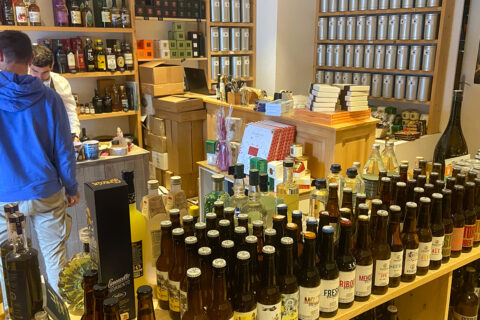 Intérieur de La Cave du coin où l'on voit des bouteilles mais aussi des pots de thé et des boites de chocolats