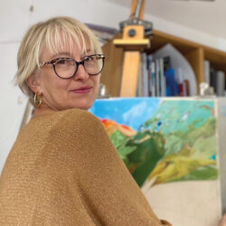 photo portrait de l'artiste Corinne Caillé réalisant une toile au pastel