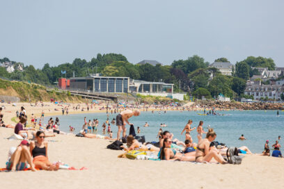 Vue d'estivants sur la plage du moulin Blanc. Certains sont sur leurs serviettes, d'autres se baignent - Agrandir l'image, fenêtre modale